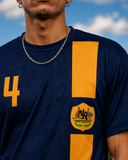 Person wearing a blue and yellow sports jersey with a logo against a blue sky.